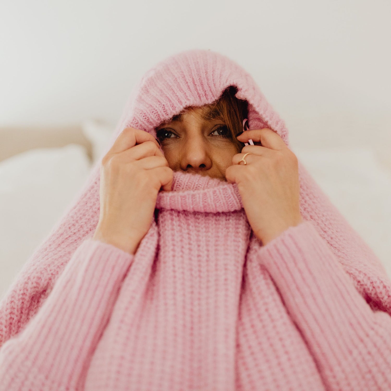 Women who covered up by pink wool jumper 